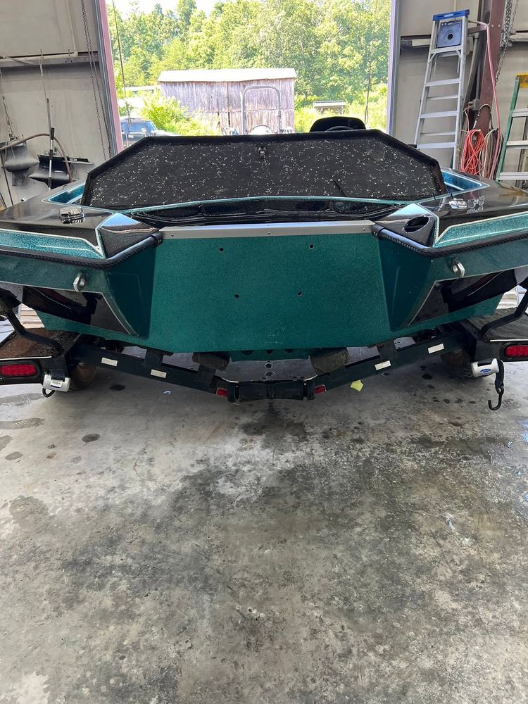 Teal metal-flake bass boat stern in the shop